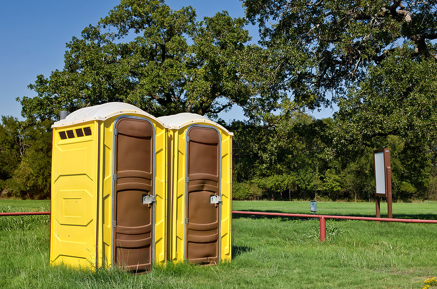 two portable toilet in the grass